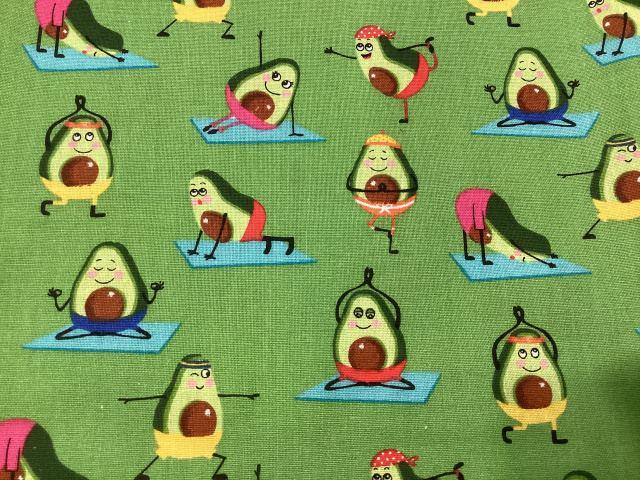 Avocado halves with faces doing yoga poses on bright green