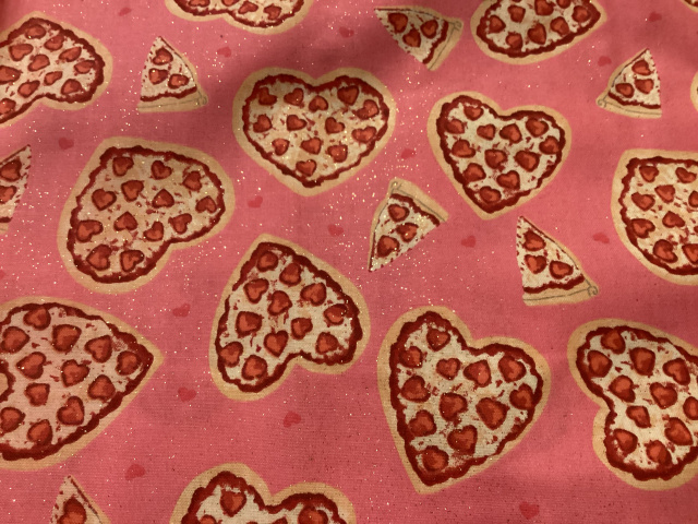 Tossed heart shaped pizzas and slices on bright pink