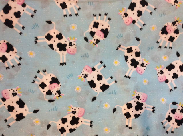 Black/white cows and yellow/white daisies on aqua