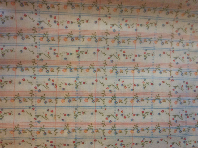 White background with alternating stripes of light blue and pink.  Sprinkled on top are tiny flowers