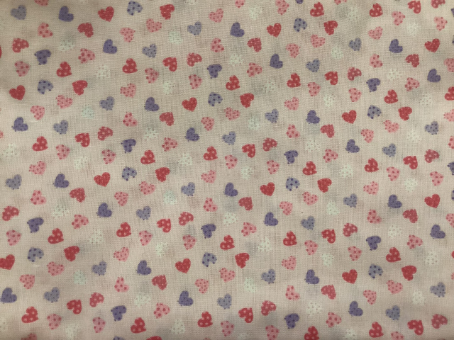 Dotted tiny hearts in pink, lavender, and white on soft pink