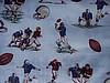 Football players in brown/blue uniforms, footballs on white