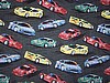 Race cars in light primary colors on black pavement