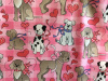 Dogs on large pink check with hearts and bows around their necks